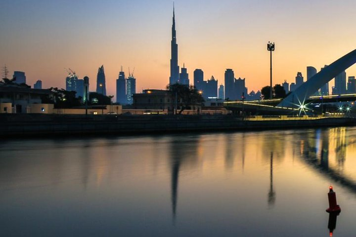 Drift along the Dubai Water Canal enjoying views of the Burj Khalifa and Dubai's skyline while savoring dinner and entertainment on a delightful evening cruise.